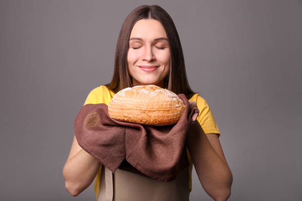 mujer joven con pan recién horneado - smelling bread bakery women fotografías e imágenes de stock