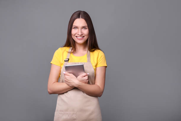 istock Young woman in apron with tablet 1214480074