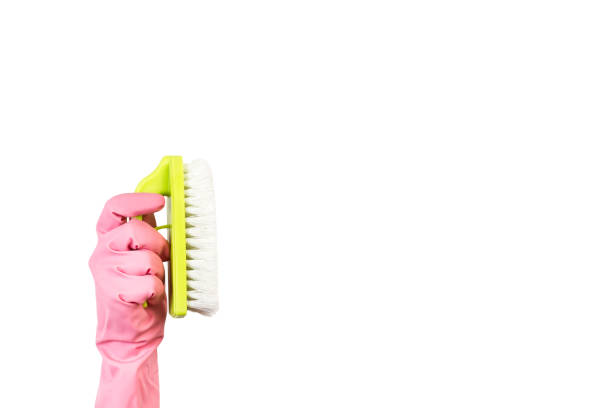 istock Hand with a rubber glove holding a cleaning brush 1214480823