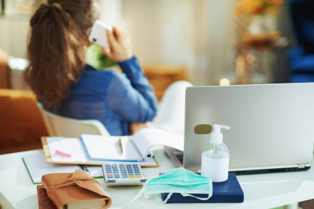 medical mask and hand disinfectant and woman talking on phone - administrator telephone office support imagens e fotografias de stock