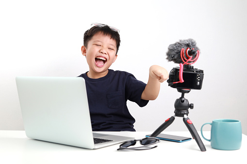 Little Asian boy making vlog, vlogger live broadcasting on social media.