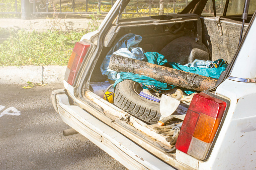 a mess in the trunk of a white car, the front and back background blurred with a bokeh effect