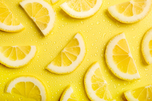 istock Fresh lemon slices on yellow background 1214485585