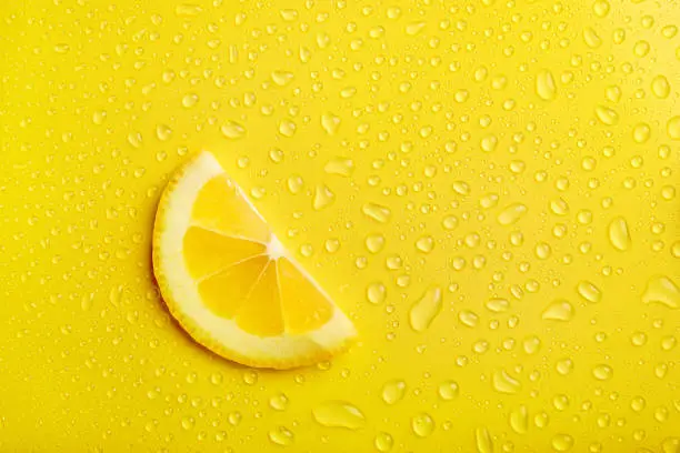 Photo of Fresh lemon slice on yellow background