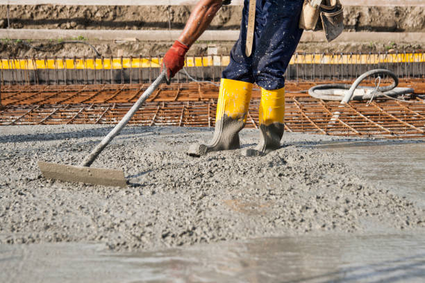 bricklayer who level the freshly poured concrete to lay the foundations of a building stock photo