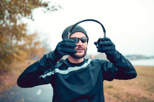 Male Setting Up His Headphones And Getting Ready For A Run