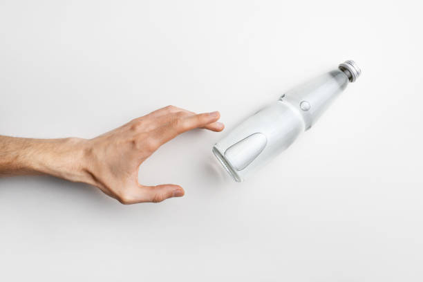 Hand reaching glass water bottle on white background