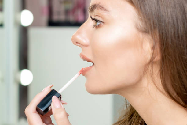 istock Woman applies lipstick. 1214488637
