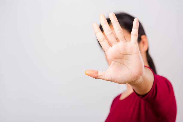 istock Asian beautiful woman itching her outstretched hand showing stop gesture front face, focus on hand on white background 1214488688
