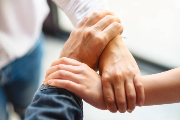istock People putting their hands in a circle together for unity and teamwork 1214489038