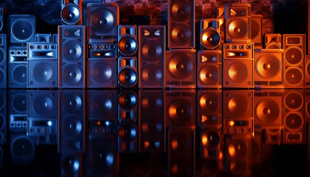 Photo of speaker system on a black background in blue and orange lighting