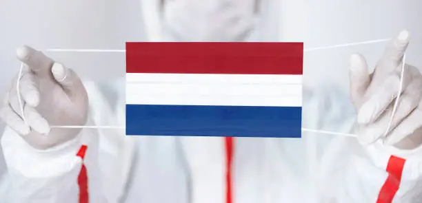 Healthcare personnel is holding Dutch Flag shaped surgical mask.