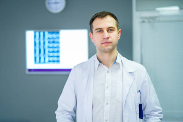 istock Doctor standing in office with x ray on the background. 1214491820