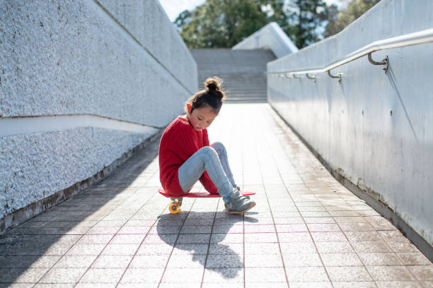 istock Girl sitting on a skateboard 1214491933