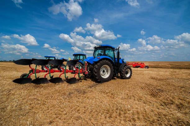 istock new blue tractor in motion working with plow. 1214493222