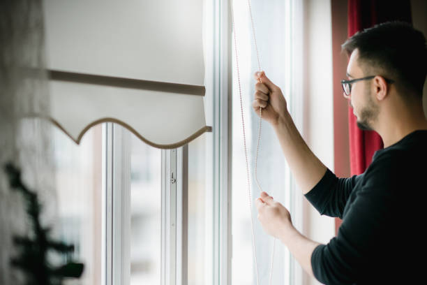 istock Man looking through the apartment window 1214495989