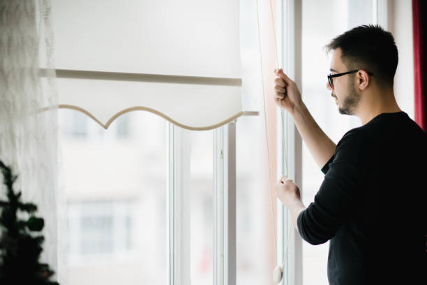 istock Man looking through the apartment window 1214496004