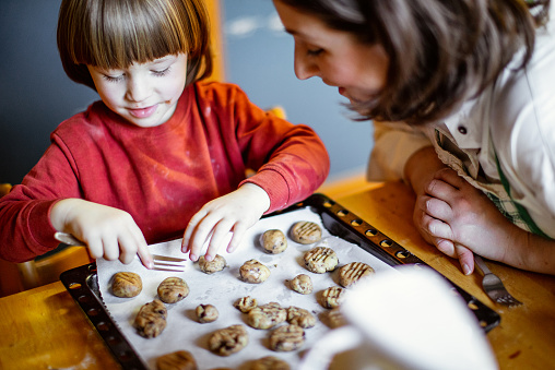Toddler Boy Making cookies with his mother