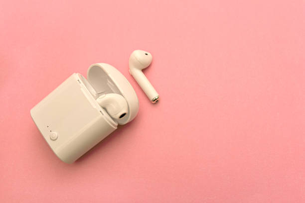 istock wireless headphones and wireless charging Case on pink background. Copy Space 1214499192