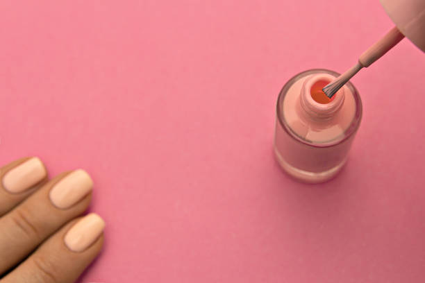 istock Pink nail polish with brush on pink background 1214499389