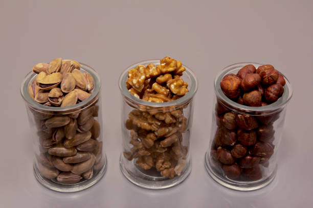 istock hazelnut, walnut and pistachio nut. mixed assorted nuts in glass box  on light background 1214499816