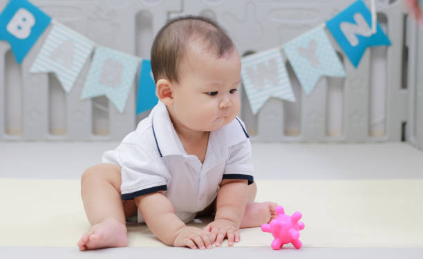 istock infant sitting play with ball in nursery 1214499845