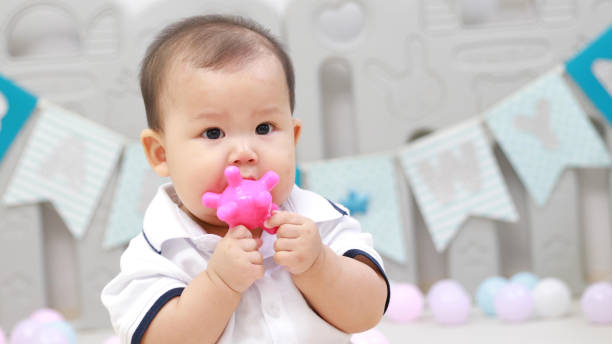 istock infant sitting play with ball in nursery 1214499848