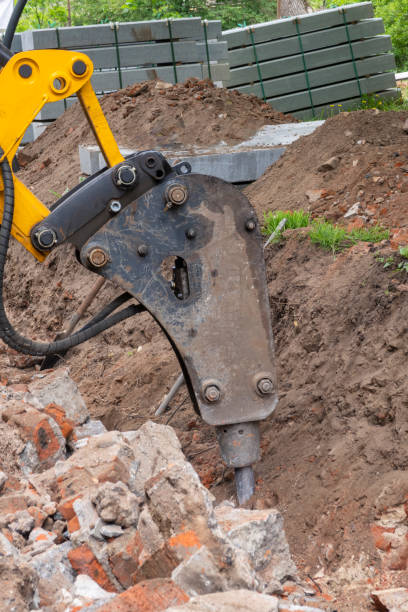 istock Excavator with hydraulic hammer breaker is crashing brick wall. Selective focus. 1214501324