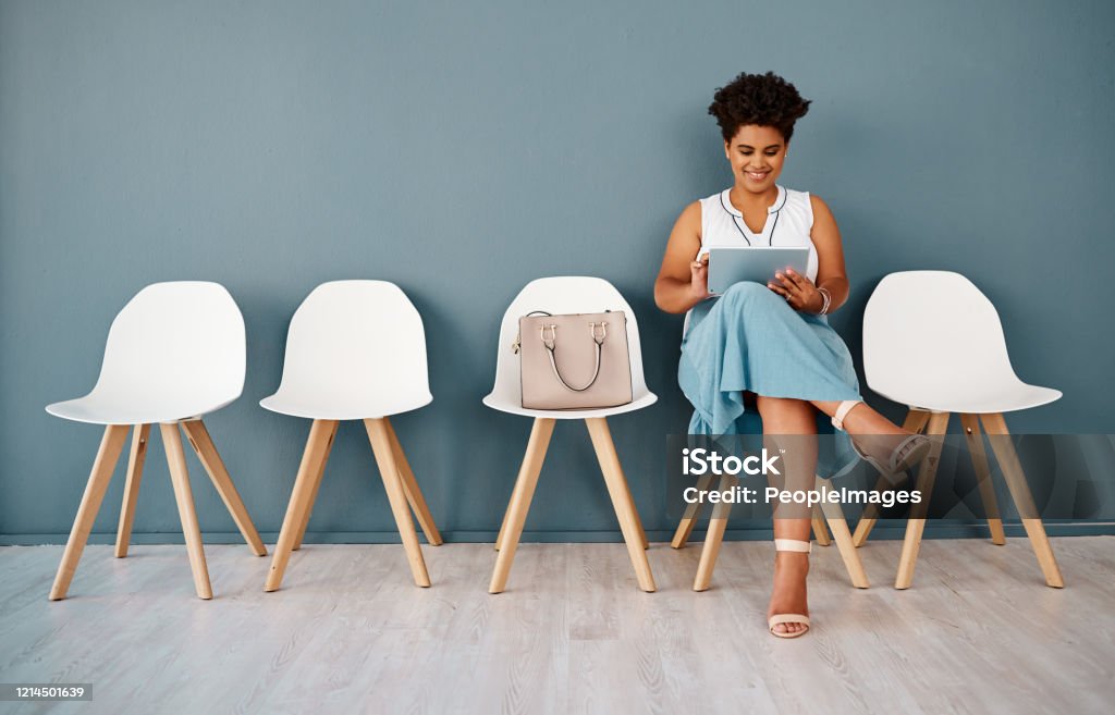 These tips will surely help me ace the interview Studio shot of an attractive young businesswoman using a digital tablet while sitting in line against a grey background 20-29 Years Stock Photo