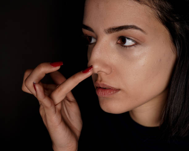 istock young woman applying concealer to her face 1214502042