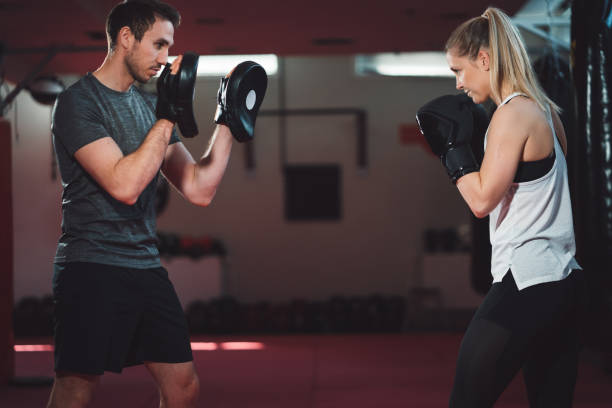 istock Female training at boxing studio with boxing trainer 1214504072