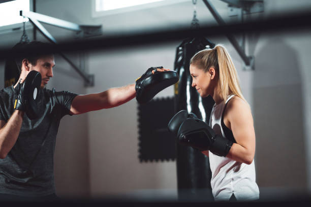 istock Sparring with her trainer - Woman boxer 1214504127