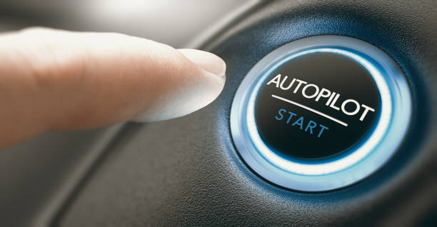 Car Autopilot Switch Button. Finger pressing an autopilot button in a self driving car. Composite image between a hand photography and a 3D background. autopilot stock pictures, royalty-free photos & images