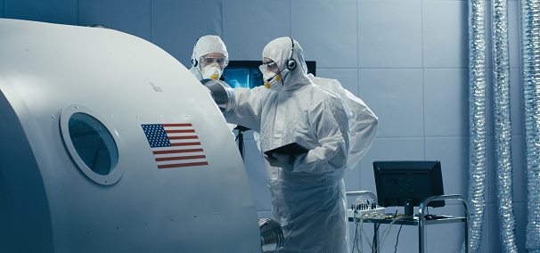 Medium shot of engineers discussing about nozzles in clean room