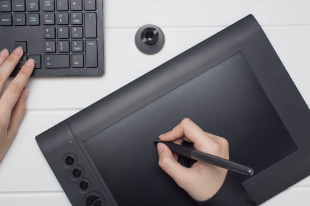 istock Graphic designer working on digital tablet. The hand draws on a graphics tablet. Freelance, designer, Illustrator. Technology, remote work, outsourcing.Project, concept, close-up, creativity. Glove and pen for a graphic tablet. 1214506666