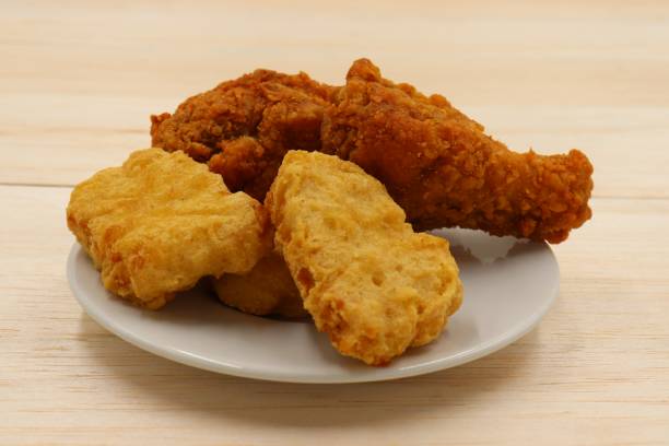 istock Nuggets and fried chicken on a white plate on wooden background 1214506778