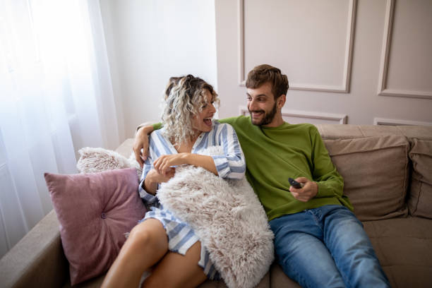 istock Happy young couple watching tv at home 1214507910