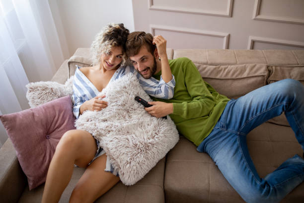 istock Happy young couple watching tv at home 1214508070