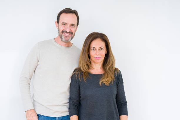 istock Beautiful middle age couple in love over isolated background Relaxed with serious expression on face. Simple and natural looking at the camera. 1214508243