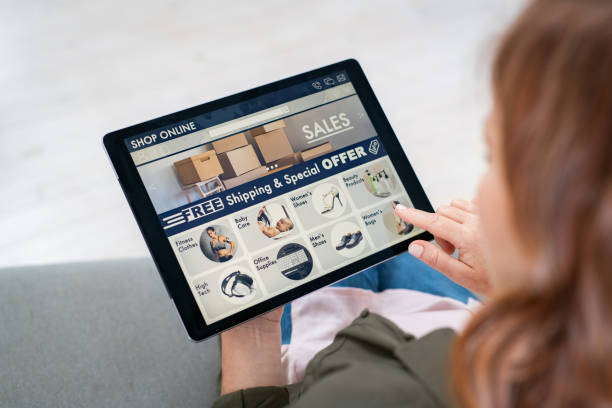 femme faisant l’emplette en ligne avec la tablette numérique - ipad shopping gift retail photos et images de collection