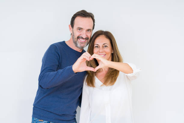 beautiful middle age couple in love over isolated background smiling in love showing heart symbol and shape with hands. romantic concept. - made man object imagens e fotografias de stock