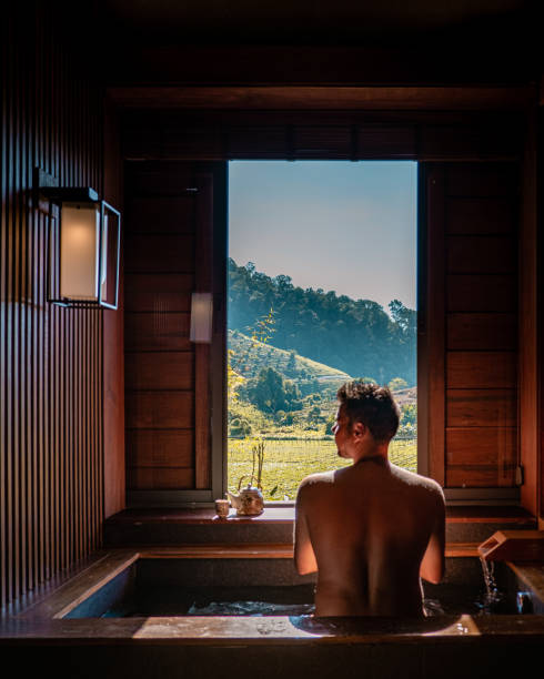 onsen bañera de madera, hombre disfruta de baño en las aguas termales en chiang mai tailandia, onsen baño japonés - baños térmicos fotografías e imágenes de stock