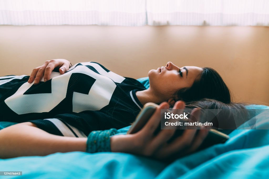 Social distancing during COVID-19 pandemic Young woman feeling worried after checking COVID-19 symptoms online and staying home for safety Teenager Stock Photo
