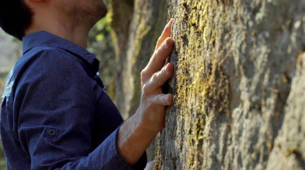 Close up of a hand of a sporty man rock-climbing in nature