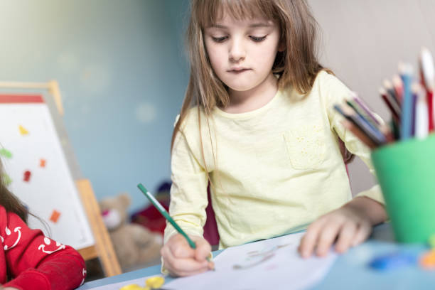 istock Sisters drawing and playing together in their bedroom 1214516857