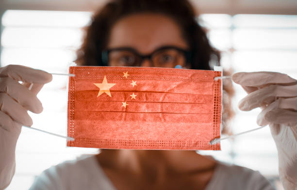 coronavírus pandêmico. close-up de jovem com máscara cirúrgica com a bandeira da china sobre ele - beijing opera mask china - fotografias e filmes do acervo