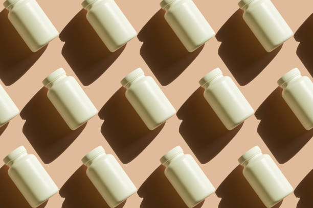 Repeating white cans of pills on a beige background