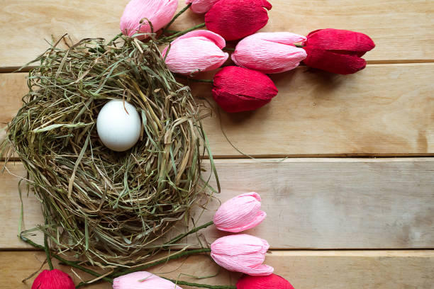 istock Hay nest with eggs and tulips on wooden background. Copy space for the text. Easter concept 1214522421