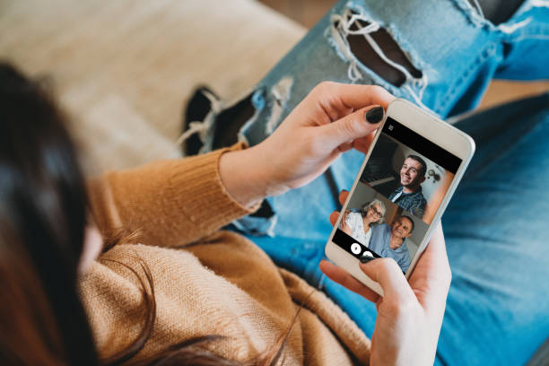 junge frau verbindet sich mit ihrer familie während der quarantäne - mobiles gerät fotos stock-fotos und bilder