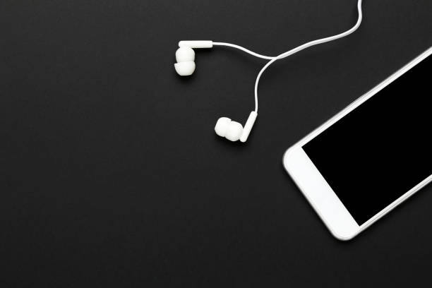 istock Earphones with mobile phone on black background 1214524078